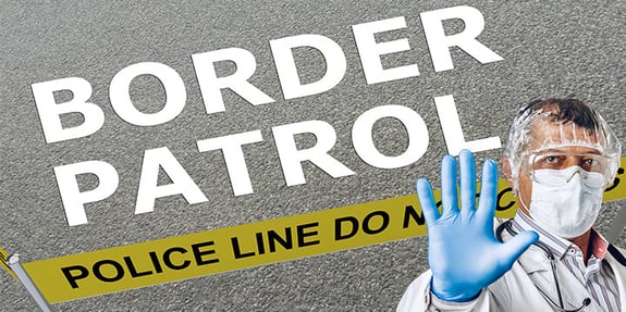 Scientist in protective gear standing at a border patrol area marked with 