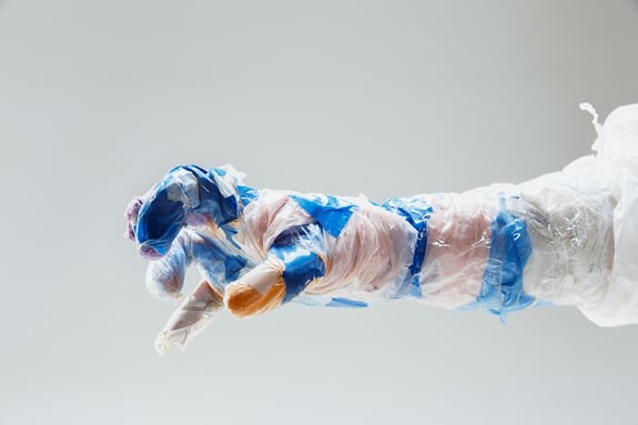 An operator wears a big plastic hand-made glove made by  plastic disposable bags