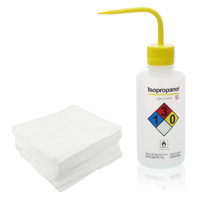 Dry polyester cleanroom wipers stacked beside an isopropanol squeeze wash bottle with yellow cap, used for cleanroom surface wiping applications.