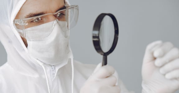 Operator in a cleanroom coverall and glasses working in a laboratory.